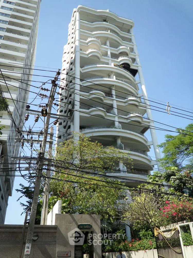 Stunning high-rise building with unique architectural design and lush greenery.
