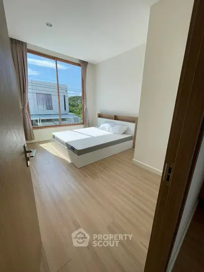 Bright bedroom with large window and modern minimalist design