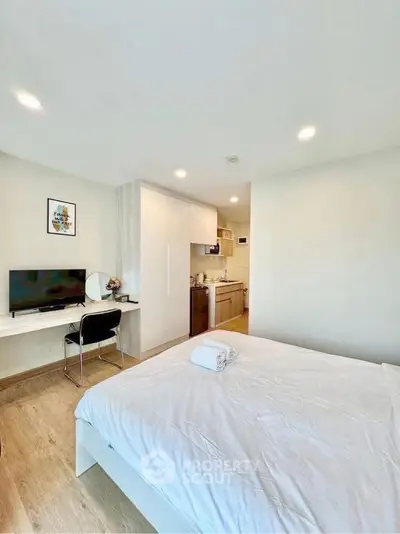 Modern studio apartment with cozy bedroom and compact kitchen