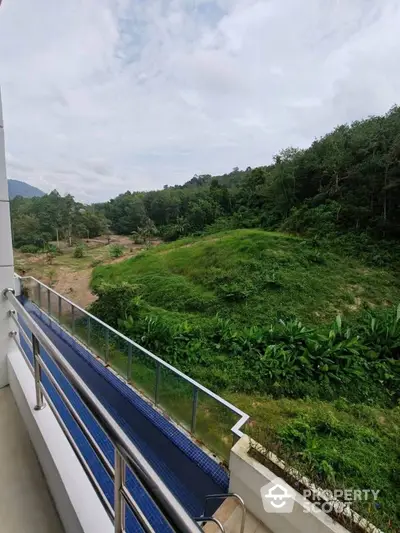 Stunning balcony view overlooking lush green landscape and hills