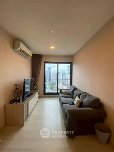 Modern living room with city view, featuring cozy sofa and entertainment unit.