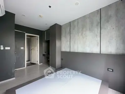 Modern minimalist bedroom with sleek dark walls and built-in storage, perfect for urban living.