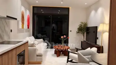 Modern living room with stylish decor and large glass doors leading to balcony.