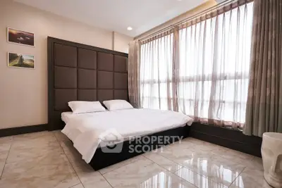 Spacious bedroom with large windows and elegant decor in modern apartment