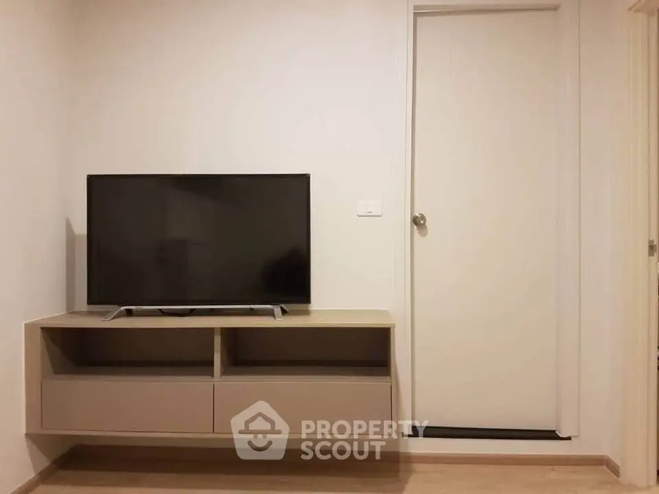 Modern living room with sleek TV stand and wall-mounted flat-screen TV.