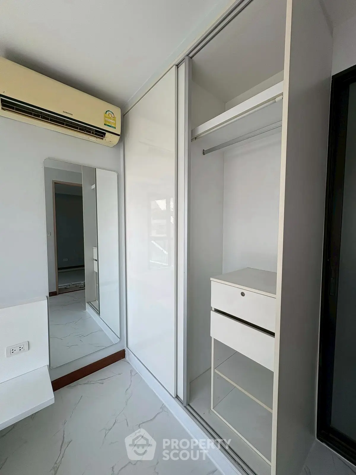Modern bedroom with sleek built-in wardrobe and air conditioning unit