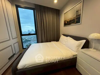 Modern bedroom with city view, featuring cozy bed and elegant decor.