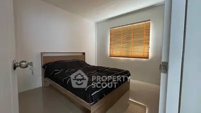 Cozy bedroom with modern design and natural light through wooden blinds.