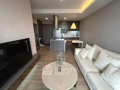 Modern open-plan living room with sleek kitchen and cozy seating area.