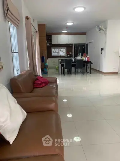 Spacious open-plan living and dining area with modern kitchen and leather seating.