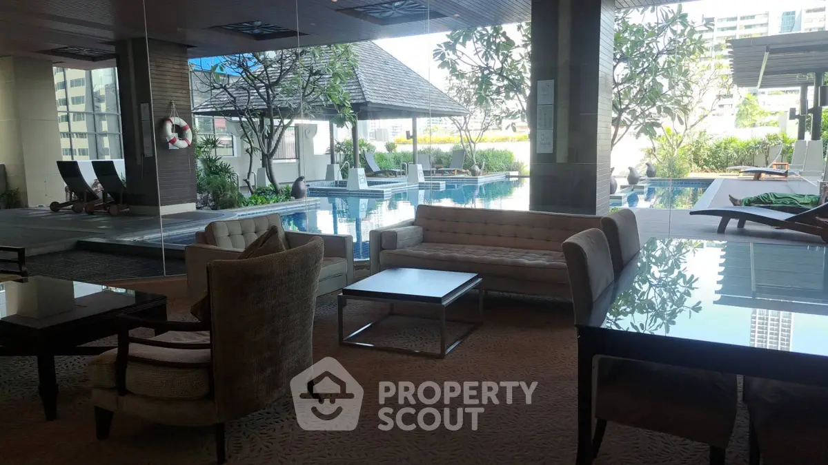 Luxurious poolside lounge area with modern furniture and lush greenery