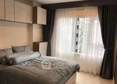 Cozy bedroom with modern decor and large window offering city view