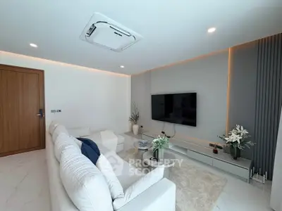 Modern living room with sleek design, featuring a large TV, comfortable sofa, and elegant decor.