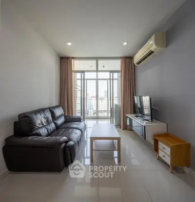 Modern living room with sleek leather sofa and large windows offering natural light