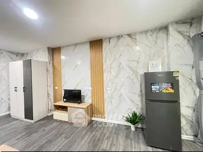 Modern interior with marble walls, sleek wardrobe, and stainless steel fridge in a stylish living space.