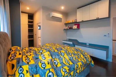 Charming bedroom with vibrant decor and modern storage solutions, perfect for a cozy living experience.