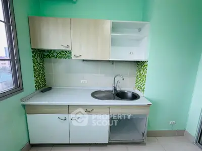 Compact kitchen with modern cabinets and green mosaic backsplash