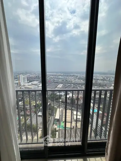 Stunning high-rise view from a modern apartment balcony overlooking the cityscape.