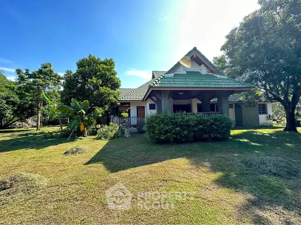 Charming countryside house with lush garden and traditional architecture under clear blue sky.