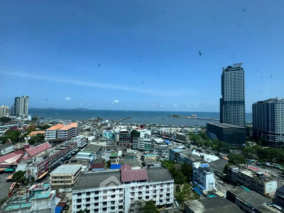 Stunning cityscape view from high-rise building overlooking ocean and skyline.