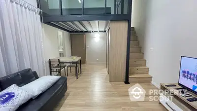 Modern duplex apartment with open-plan living area, sleek wooden flooring, and an elegant staircase leading to an upper level, showcasing a perfect blend of style and functionality.