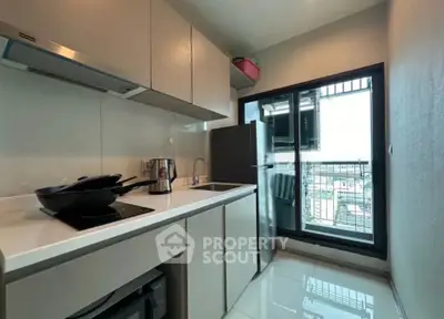 Modern kitchen with sleek cabinetry and balcony view in urban apartment
