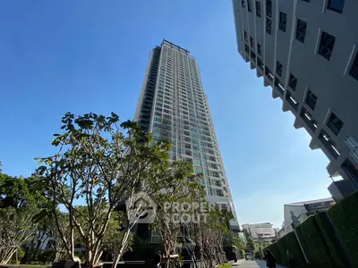 Stunning high-rise building with lush greenery and clear blue sky, perfect for urban living.