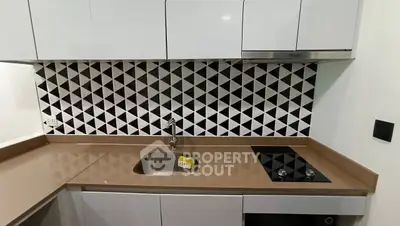 Modern kitchen with sleek cabinets and stylish geometric backsplash