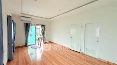 Spacious unfurnished room with wooden flooring and large windows, perfect for customization.
