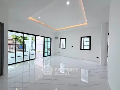 Spacious modern living room with large windows and elegant marble flooring