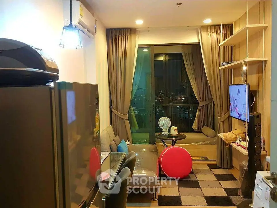 Modern living room with city view, cozy seating, and stylish decor in a high-rise apartment.