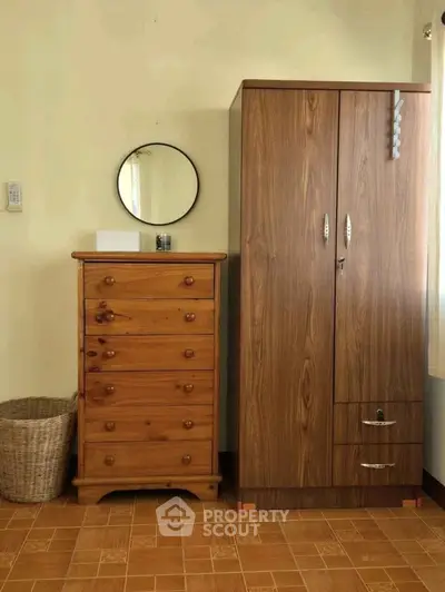 Cozy bedroom corner with wooden wardrobe and dresser, perfect for storage and organization.