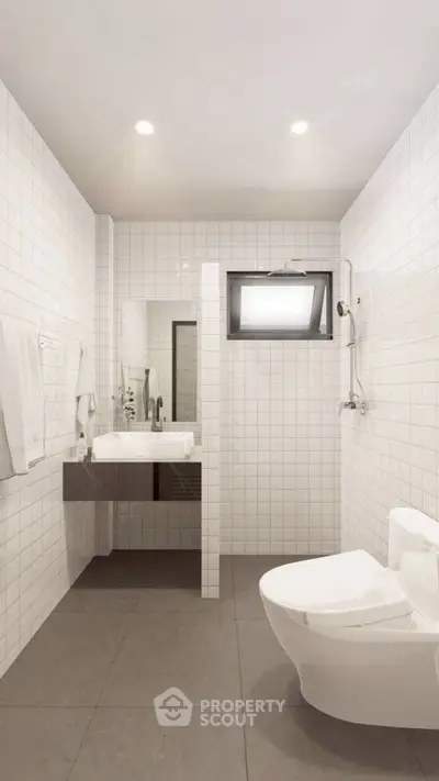 Modern minimalist bathroom with sleek fixtures and white tile design.