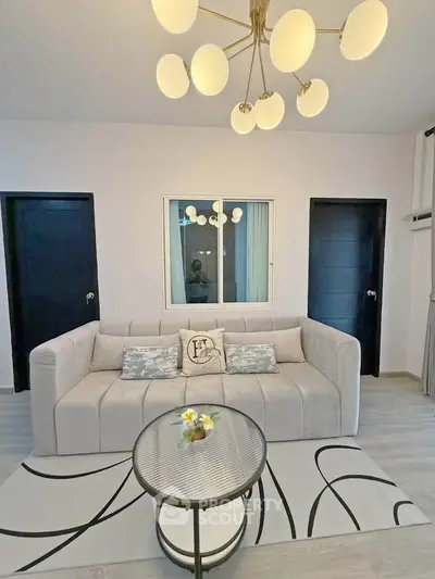 Modern living room with stylish chandelier and cozy sofa in elegant apartment.