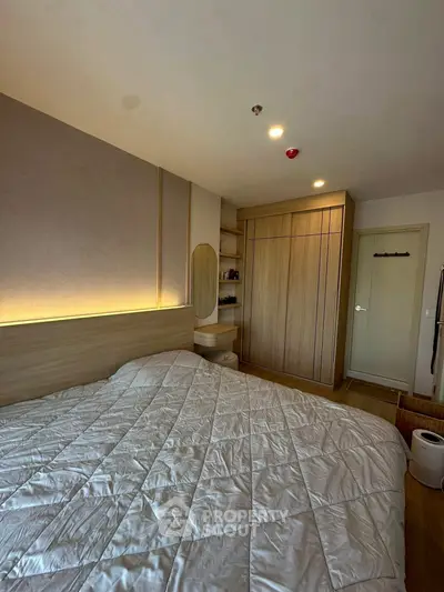 Cozy bedroom with modern wooden wardrobe and soft lighting, perfect for relaxation.