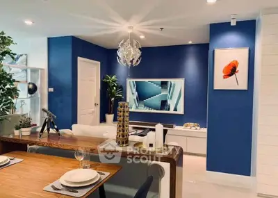 Modern living room with stylish decor, blue accent wall, and elegant dining setup.