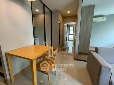 Modern apartment interior with dining area and cozy living space, featuring sleek furniture and bright lighting.