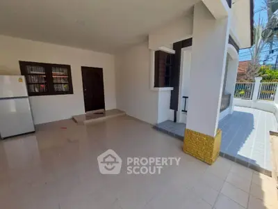 Spacious exterior view of a modern home with tiled flooring and a refrigerator, perfect for family living.