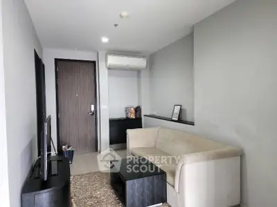 Modern living room with sleek furniture and neutral tones, featuring a comfortable sofa and stylish decor.