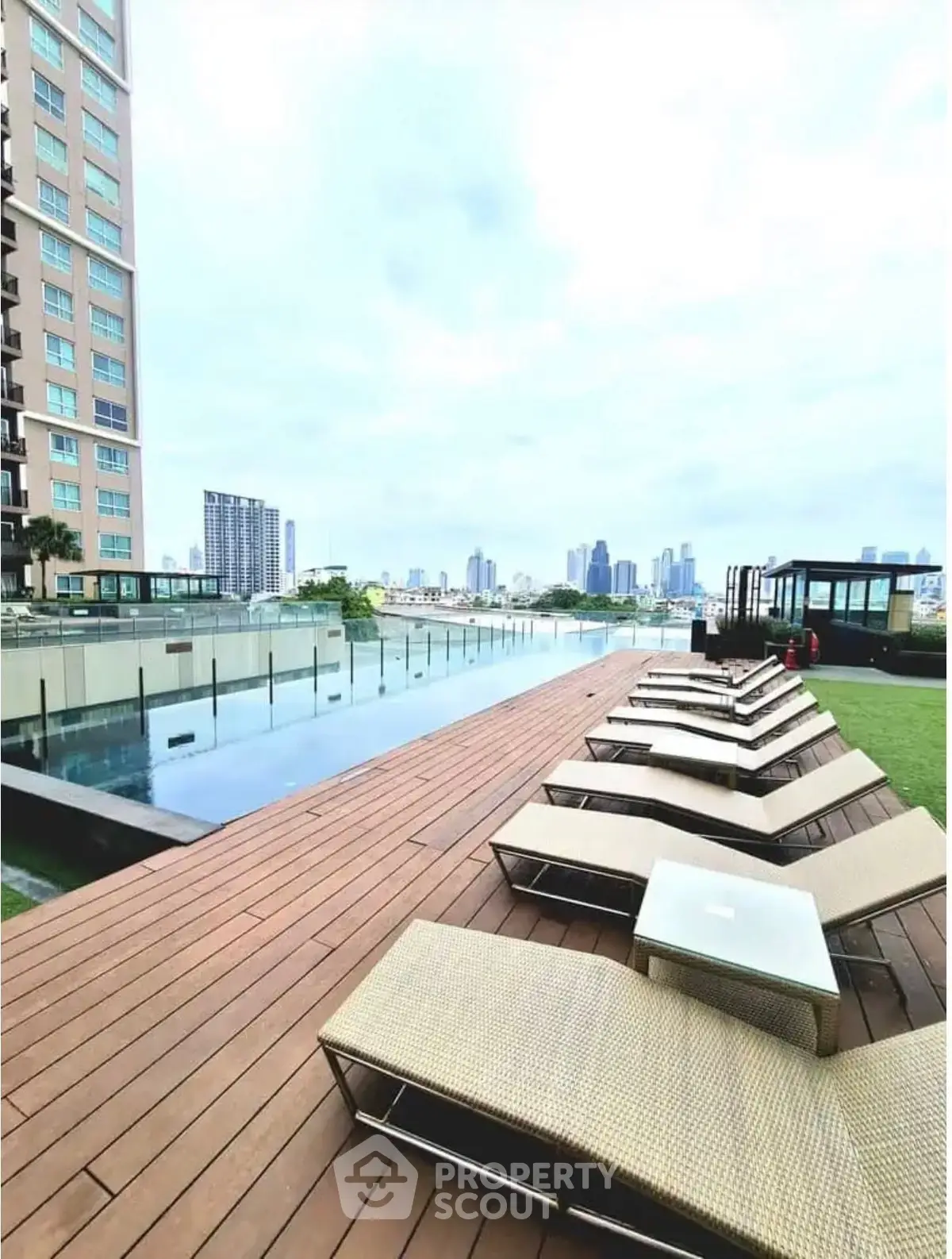 Luxurious rooftop pool with city skyline view and sun loungers, perfect for relaxation and leisure.