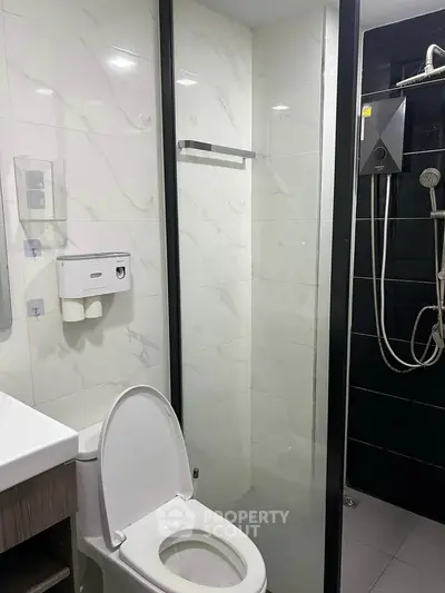 Modern bathroom with sleek shower and toilet in contemporary apartment.
