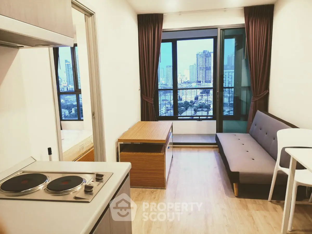 Modern apartment with city view, featuring compact kitchen and cozy living area.