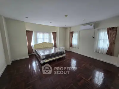 Spacious bedroom with elegant parquet flooring and natural light