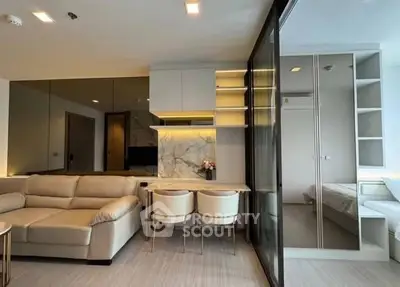 Modern living room with elegant decor and adjacent bedroom in open layout apartment.
