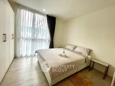 Spacious bedroom with large window and modern decor