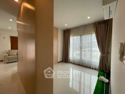 Spacious modern living room with large windows and elegant curtains