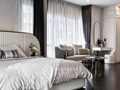 Luxurious modern bedroom with elegant decor and cozy seating area