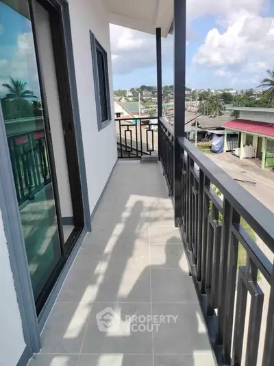 Spacious balcony with modern railing and scenic neighborhood view, perfect for relaxation and outdoor enjoyment.
