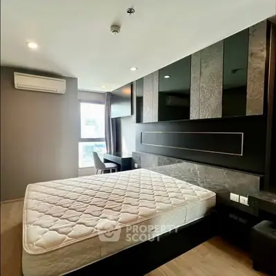 Modern bedroom with stylish decor and large window offering natural light.