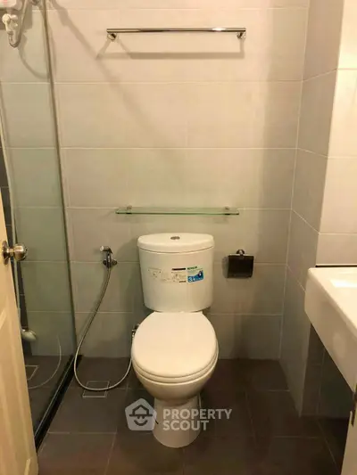 Modern bathroom with sleek fixtures and glass shower enclosure in a contemporary apartment.